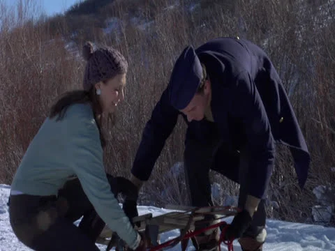 A couple’s plays snow sledding, winter activity Stock Footage 23105474