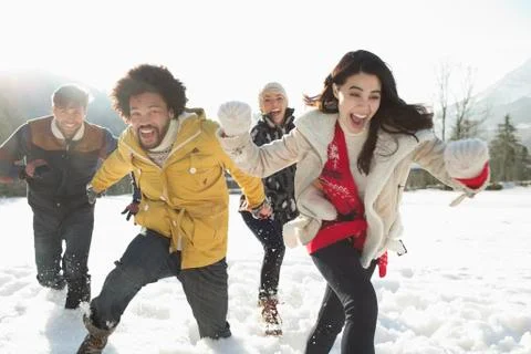 Couples running in snow Stock Photos