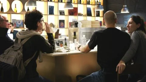 Couples sitting at a bar counter dining in a modern restaurant Stock Photos