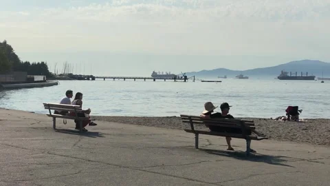 Couples sitting on benches with beach and ocean views Stock Footage 280806533