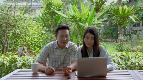 Couples using laptops with credit Cards to shop online in the living room Stock Footage 119494212