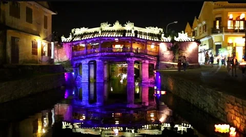 Couples walk across a bridge decorated with red lanterns at night Stock Footage 65376344