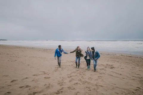 Couples Walk Along Winter Beach Stockfoto's