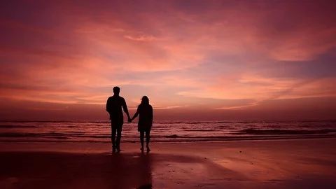 Couples walking in beach at sunset Stock Footage 120525841