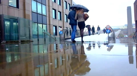 Couples walking in the rain with umbrellas Stock Footage 67684726