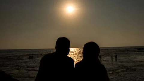Couples Watching Sunset at the Beach Stockfoto's