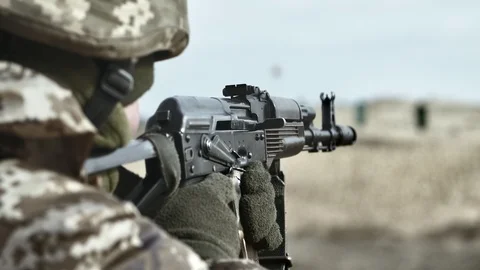 Courageous fighter is attacking enemy with assault rifle in a field in slo-mo Stock-Footage 104649277