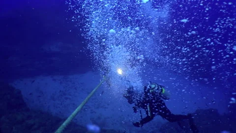 Courageous scuba diver drops down ocean floor using rope. Stock Footage 232783303