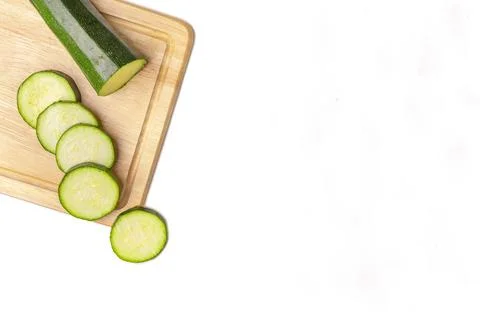 Courgettes Cucurbita pepo cut open on wooden board on white copy room Stock Photos