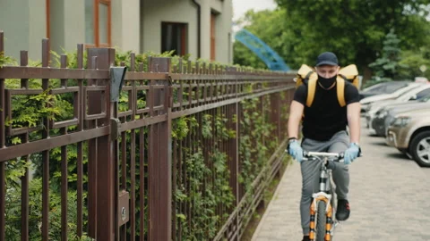 Courier on a bicycle uses an intercom system Stock Footage 131934460