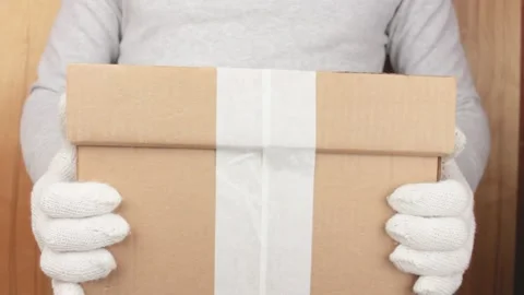 Courier with a box in his hands .Delivery of the order in a box with gloves. Stock Footage 201716935
