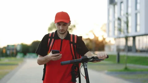 Courier checking customer address on his phone, food delivery outbreak. Food Stock Footage 194606067
