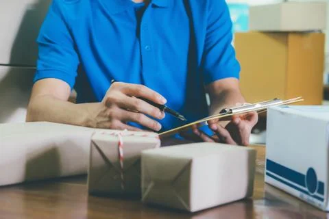 Courier checking the delivery receipt list in office. Stock Photos