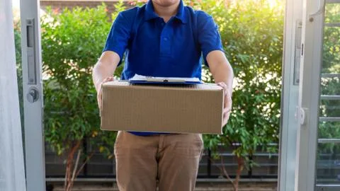 Courier delivery man checking or holding cardboard parcel package to deliver Photos