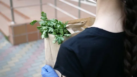Courier, delivery man in protective mask, medical gloves delivers takeaway food Stock Footage 134393448