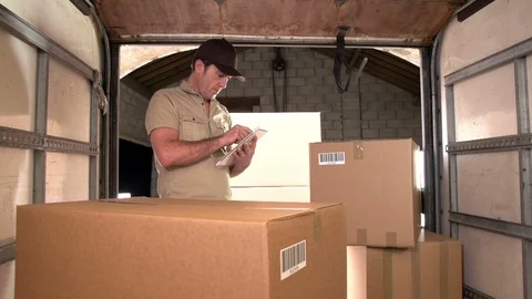Courier / Delivery man using a Digital Tablet with parcels in Freight truck. 스톡 동영상 125133174