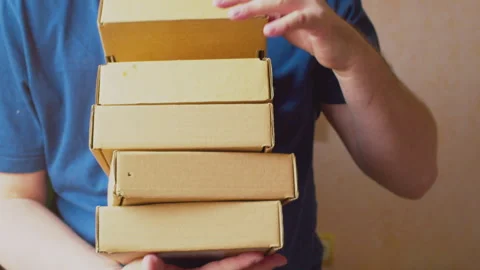 A courier hands over a stack of cardboard boxes 스톡 동영상 273507856