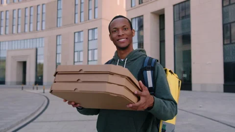 Courier hands pizza boxes to the camera.Professional delivery to business center Stock Footage 254097118