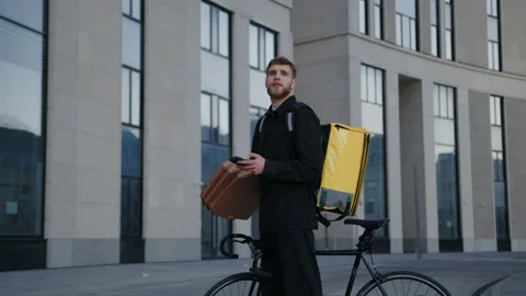 The courier is looking for the right building for pizza delivery Stock Footage 219462346