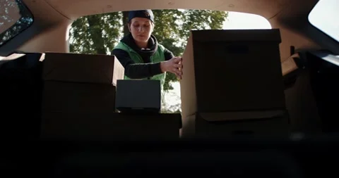 Courier opens delivery van door and puts cardboard box package. Stock Footage 140609229