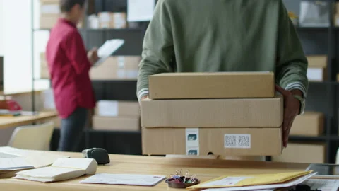 Courier Picking Up Boxes in Delivery Service Office Stock Footage 228488024