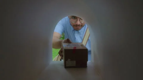 Courier Placing Two Parcels Packed in Boxes into Mailbox Stock Footage 279295056