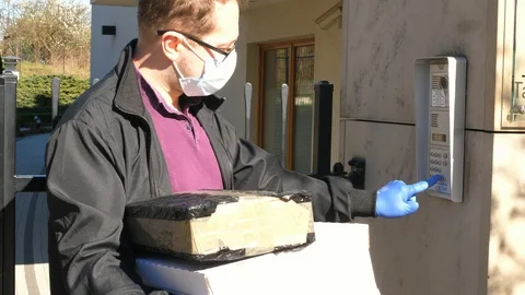 Courier in protective gloves waiting for open gate and calling Stock-Footage 129100607