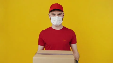 Courier in protective mask and gloves offering parcel Stock Footage 149623735