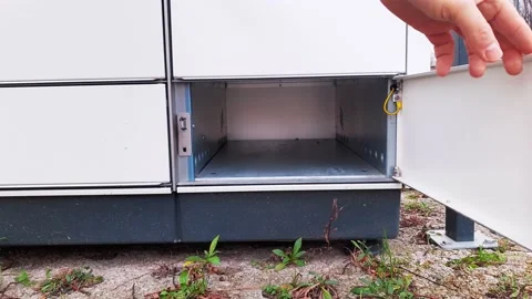Courier Puts Cardboard Package Into Parcel Locker Stock Footage 145000622