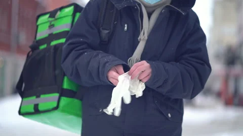 Courier puts on gloves outside in winter Stock Footage 146100768