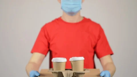 Courier in red uniform, protective mask and gloves  Stock Footage 128991560