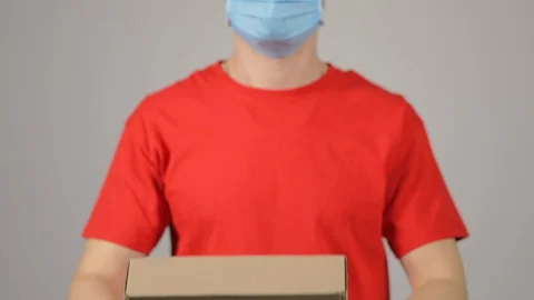 Courier in red uniform, protective mask and gloves  Stock Footage 128991586