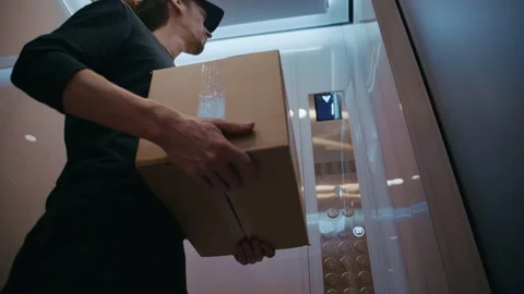 Courier Riding Elevator with Parcel in Residential Building 库存影片 322512546