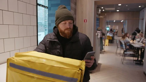 Courier spends time on the phone.The delivery man is waiting for the order Stock Footage 236089090