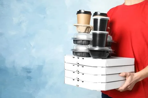 Courier with stack of orders on color background, space for text. Food delive Foto stock