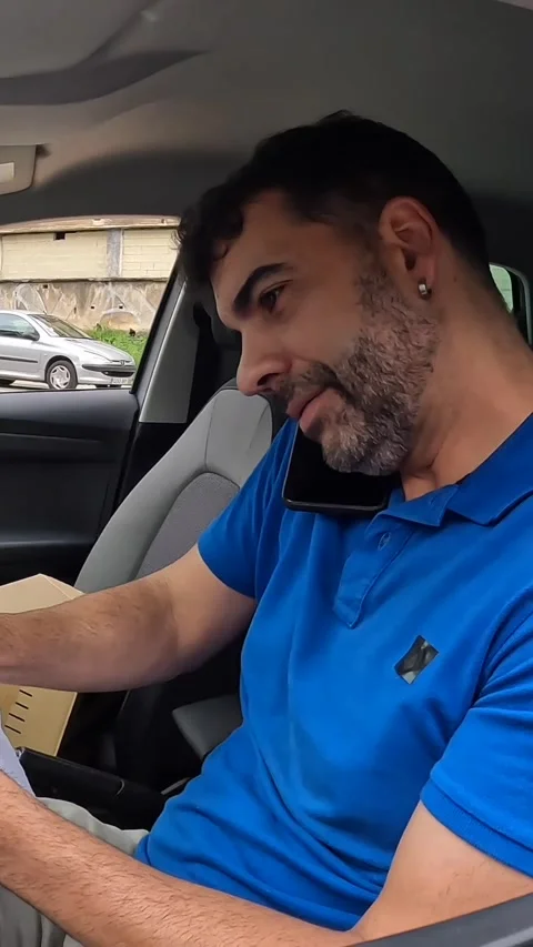 Courier talking to the mobile inside a van with packages Stock Footage 286408091