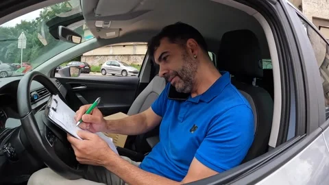 Courier talking to the mobile inside a van with packages Stock Footage 286408262