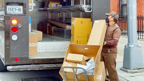 Courier unloading cardboard boxes from delivery truck in New York Stock Footage 335203380