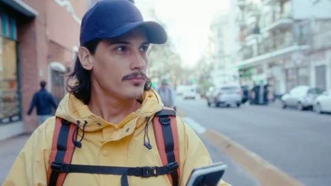 Courier Using Phone for Navigation on Urban Street Stock Footage 253754092