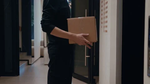 Courier Waiting in Elevator with Package Stockbeeldmateriaal 322512839