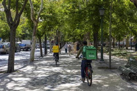 Couriers for the delivery services Uber Eats and Glovo in Lisbon, Portugal Stock Photos