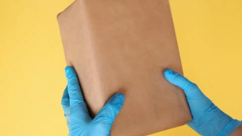 Courier's hands in protective gloves holding parcel. Contactless delivery. Stock Footage 130528020