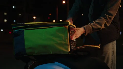 Courier's hands taking out pizza boxes from a thermos bag outside Stock Footage 214877615
