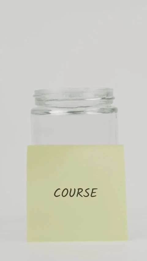 Course text or word on yellow sticky note attached to glass jar with hand Stock Footage 311701216