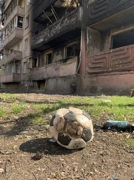 Courtyard of a destroyed multi-storey building after an airstrike. Soccer bal Stock Photos