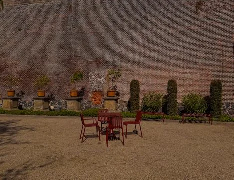 A courtyard featuring a secluded table with several chairs Stock Photos