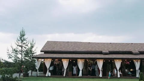 Courtyard with a seating area for a buffet on a clear summer day with guests Stock Footage 270962978