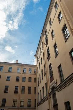 A courtyard surrounded by classic architecture under a bright blue sky Stock Photos