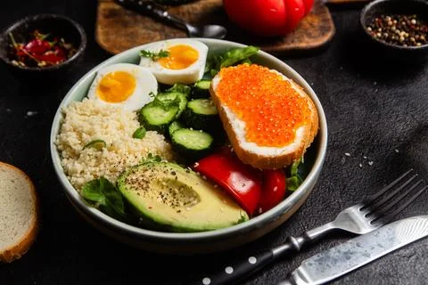 Couscous with boiled egg and vegetables in a plate on the table Stock Photos