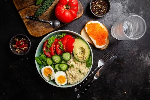 Couscous with boiled egg and vegetables in a plate on the table Stock Photos